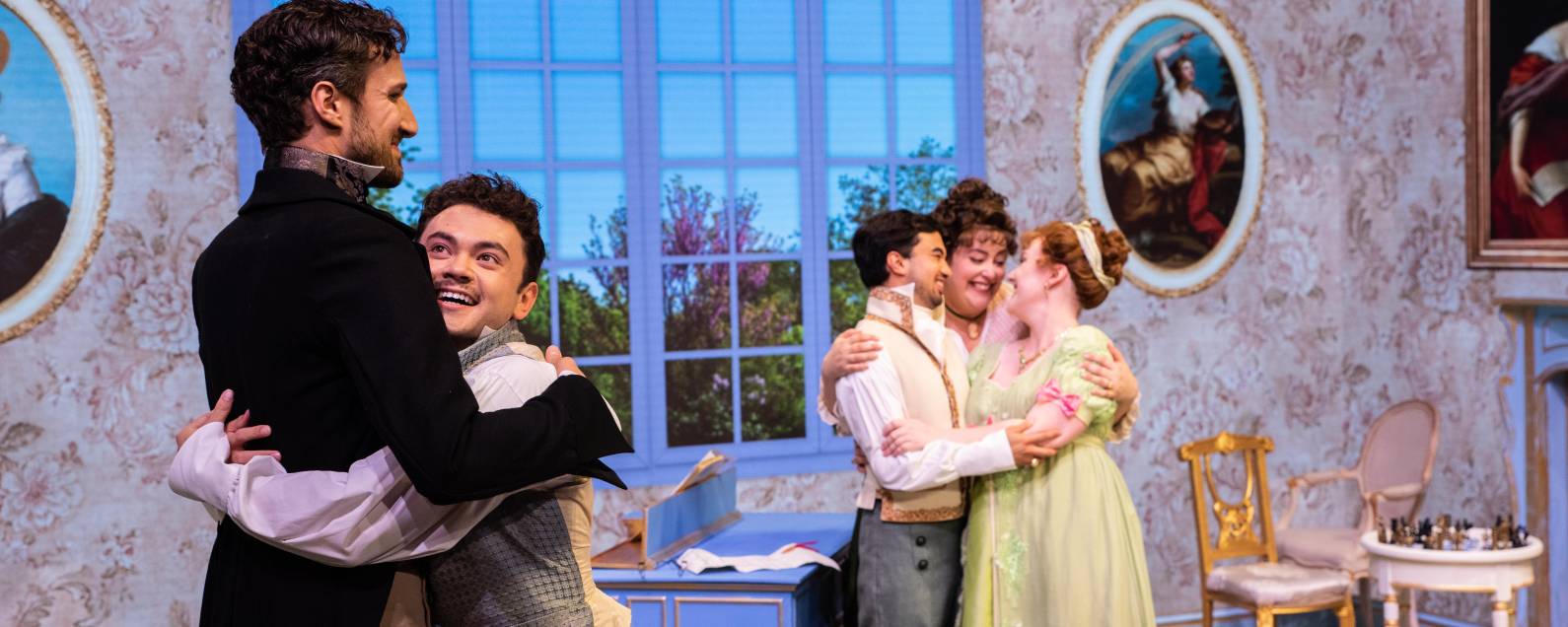 Characters share comically exaggerated group embraces in a scene from The Barber of Seville.